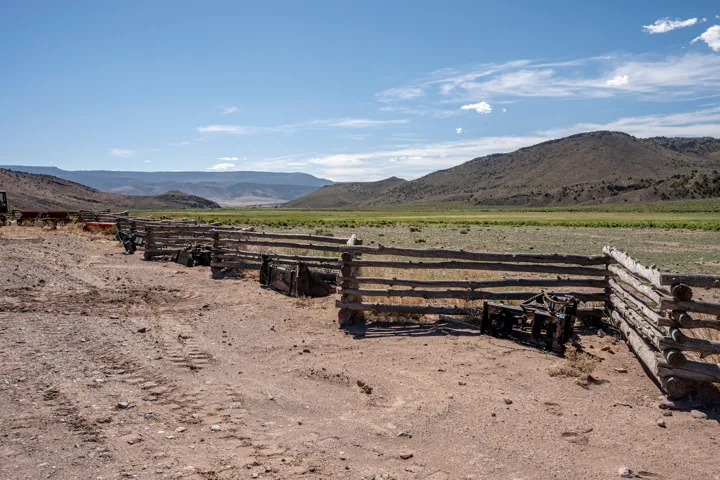 Rustic wood fence bordering an expanse of natural terrain