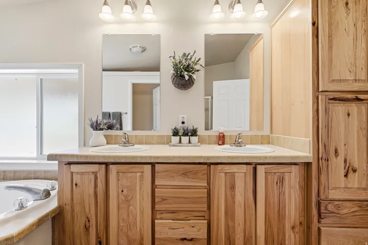 Double vanity featuring two integrated sinks set in a laminate countertop with a matching backsplash