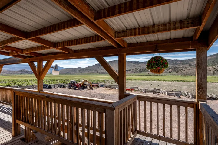 Expansive covered wooden deck featuring a metal roof and open balustrade