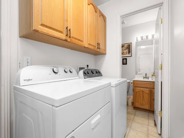 Dedicated laundry area featuring overhead natural wood cabinetry