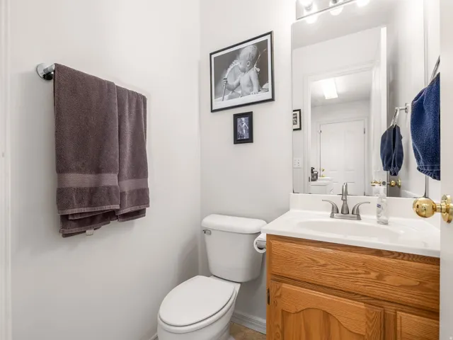 Vanity with wood-finish cabinetry, integrated sink, and brushed nickel faucet