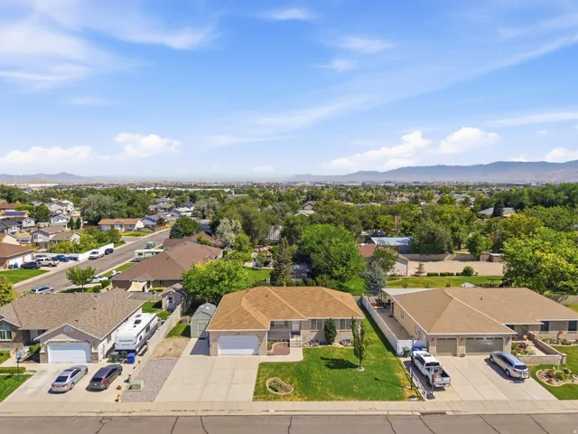 Ranch-style residence featuring a prominent front lawn, a concrete driveway, and an attached two-car garage