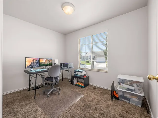 Carpeted room with a ceiling-mounted light fixture
