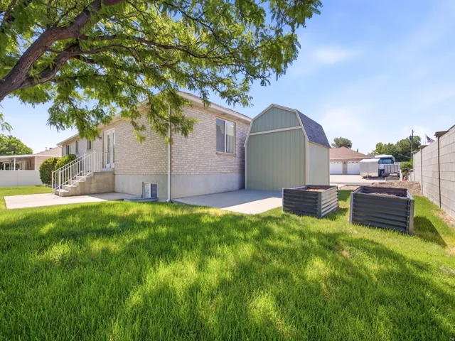 Expansive grass yard featuring two raised garden beds