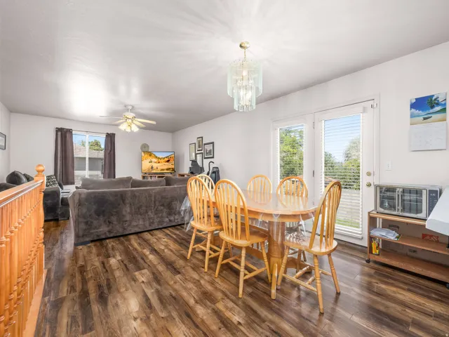 Spacious dining area featuring wood-finish flooring and a contemporary chandelier
