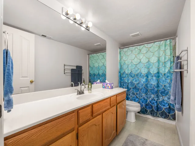 Bathroom featuring a vanity with light wood-finish cabinetry, a white countertop, and an integrated sink