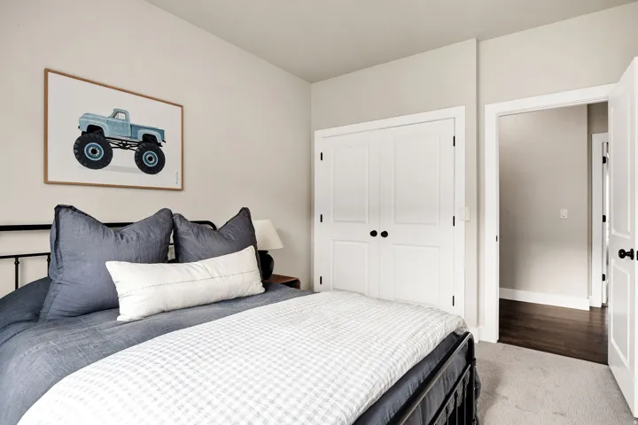 Room featuring light neutral wall paint, white trim, and a built-in closet with bifold doors