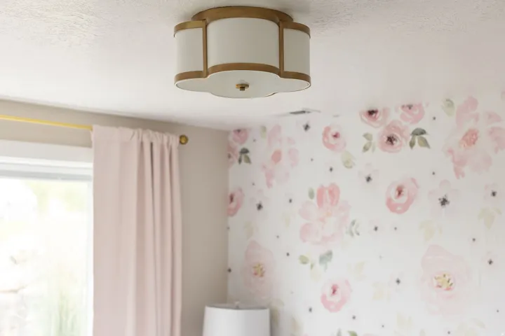 Decorative ceiling-mounted light fixture featuring a scalloped design and gold-tone trim
