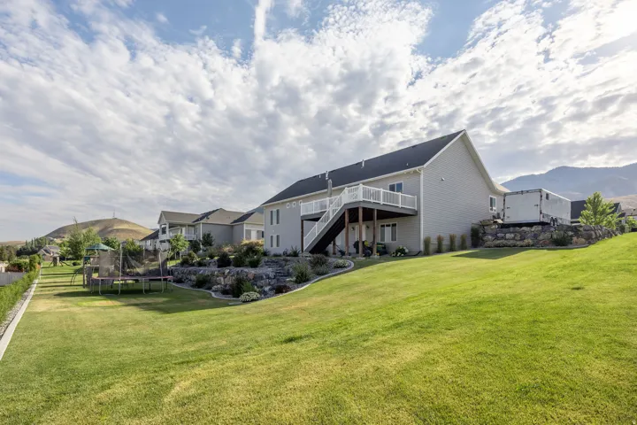Expansive green lawn with a two-story gray siding residence