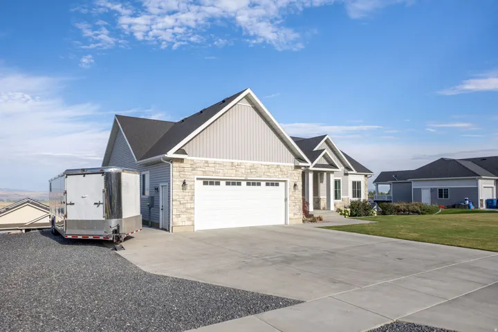 Ranch-style residence featuring stone veneer and light grey siding accents