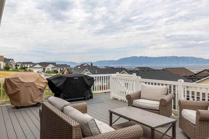 Spacious outdoor deck featuring composite decking and white railing, with distant mountain scenery
