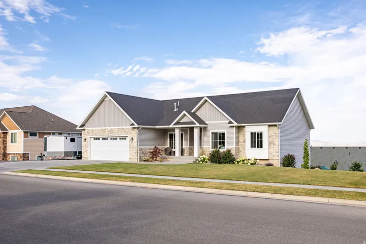 Contemporary ranch-style residence featuring a combination of light gray siding and stone veneer