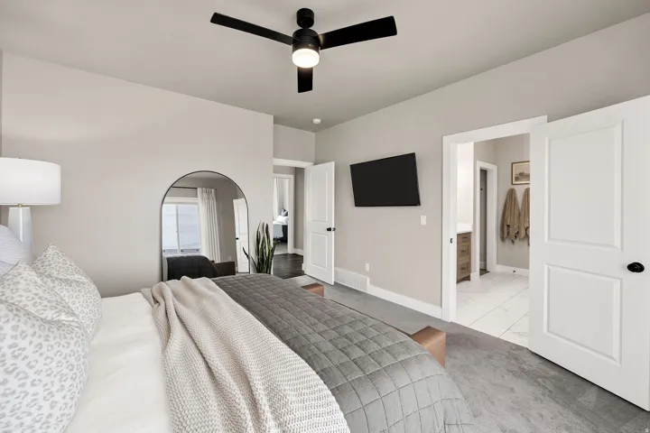 Neutral-toned bedroom featuring a contemporary black ceiling fan with integrated lighting