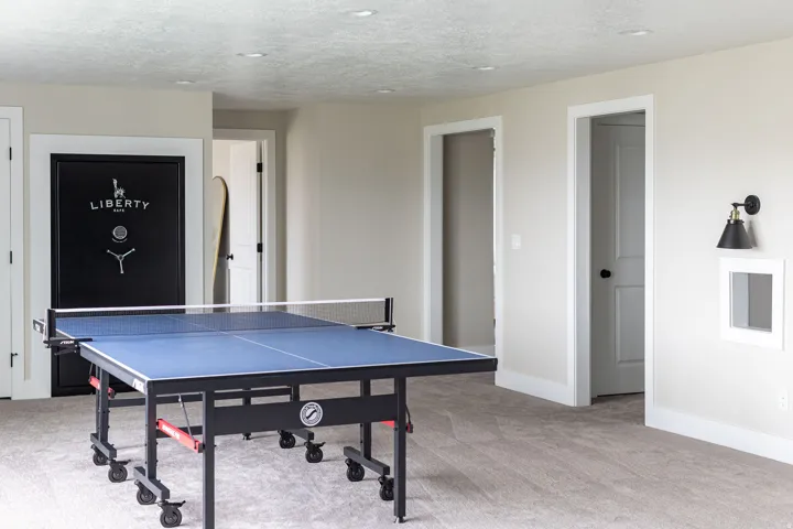 Spacious carpeted room featuring recessed lighting, multiple interior doorways, and a built-in wall sconce
