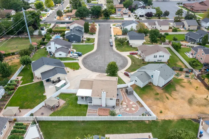 Aerial perspective of a cul-de-sac neighborhood featuring a white vinyl fence enclosing a private yard with a gazebo