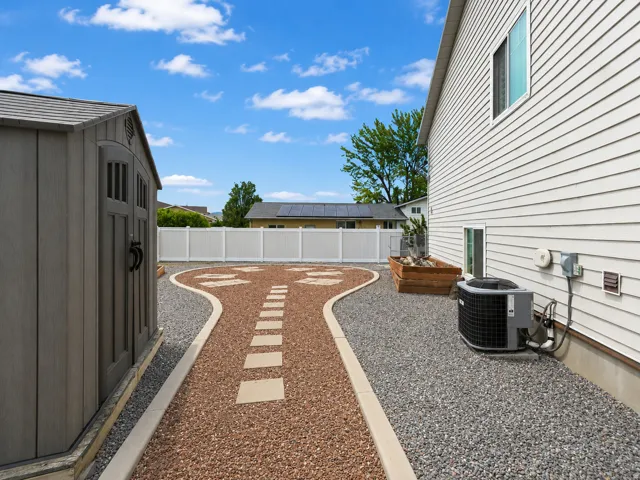 Low-maintenance backyard featuring a gravel landscape with a stepping stone pathway