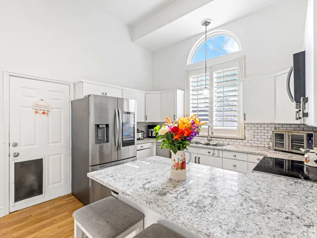 Kitchen featuring white cabinetry, subway tile backsplash, and granite countertops
