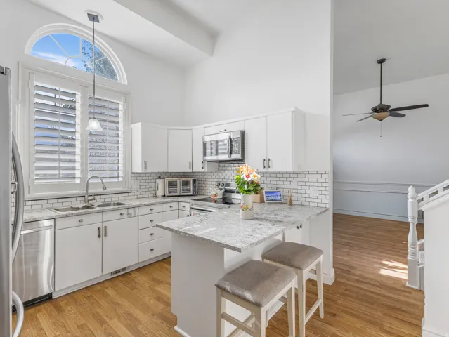 Kitchen featuring white cabinetry, granite countertops, and a subway tile backsplash