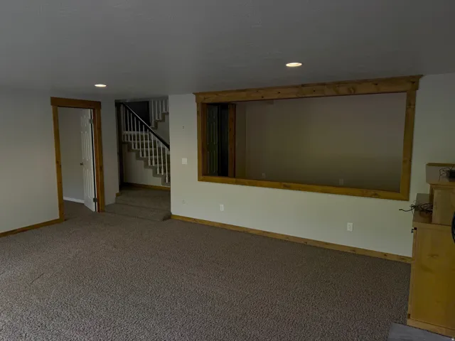Carpeted interior space featuring wood-finish trim and recessed lighting