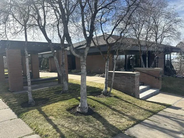 Mid-century modern exterior featuring brick construction, a flat roofline, and expansive windows