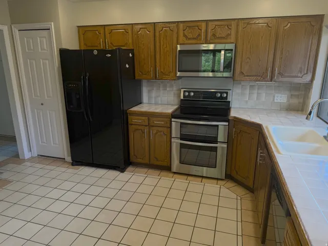 Kitchen featuring wood cabinetry, stainless steel appliances, and a tile backsplash