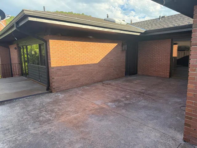 Expansive stamped concrete patio with brick and siding exterior walls