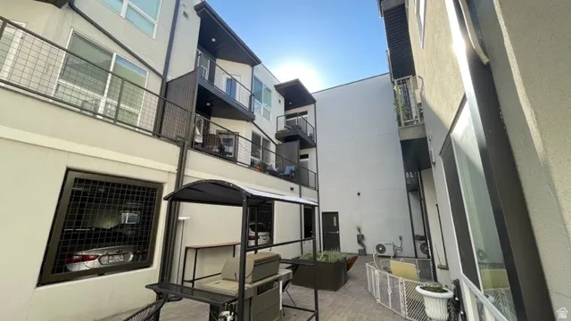 Courtyard area featuring paver flooring, built-in planters, and multi-story buildings with balconies