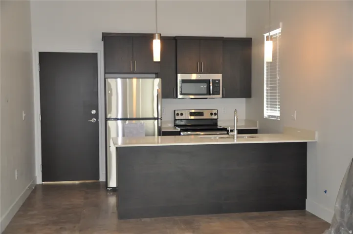 Modern kitchen featuring dark wood-finish cabinetry and a light-colored countertop