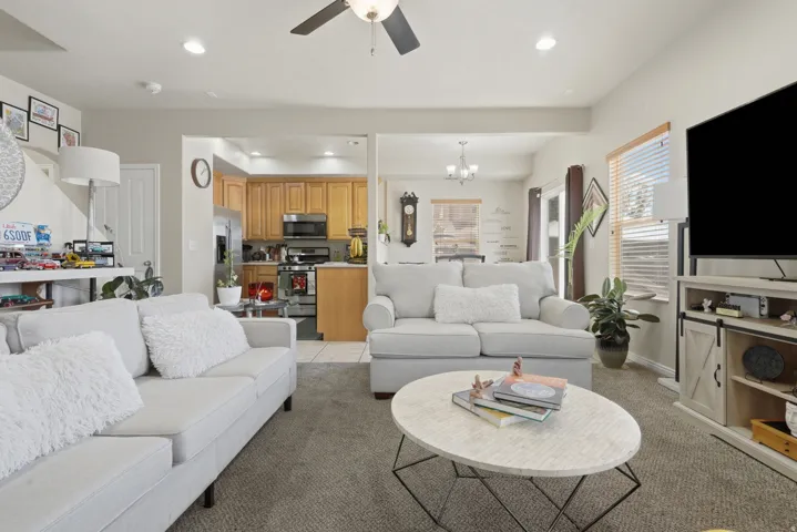 Open-concept living area featuring neutral-toned carpeting and light wall finishes