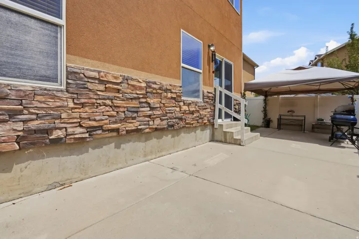 Spacious concrete patio with a stone veneer and stucco exterior