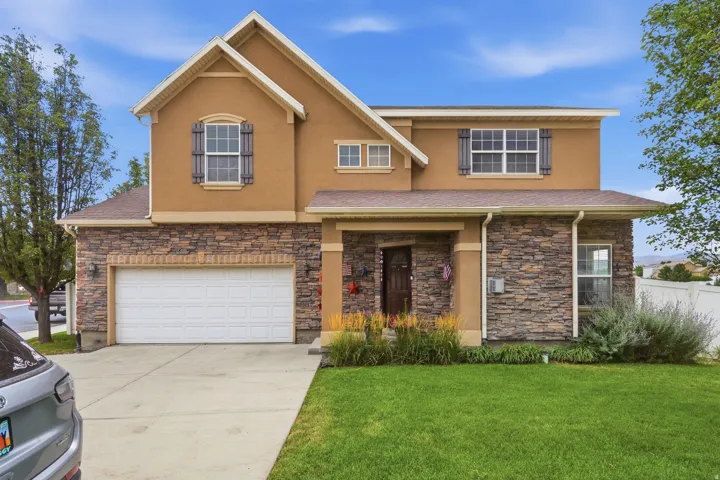 Two-story residence featuring a combination of stucco and stone veneer siding