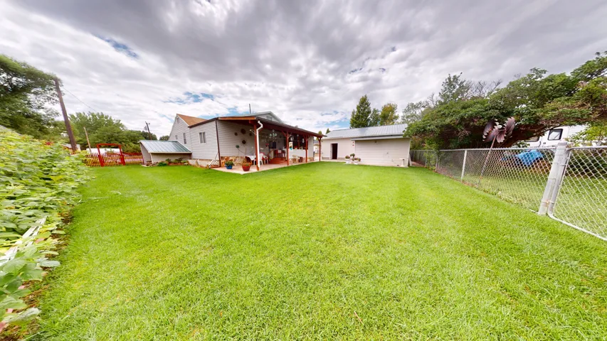 Expansive green lawn with a chain-link fence, providing an outdoor recreation area