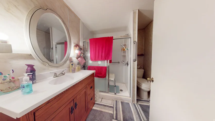 Bathroom vanity featuring a wood-finish cabinet, white countertop, and an oval mirror