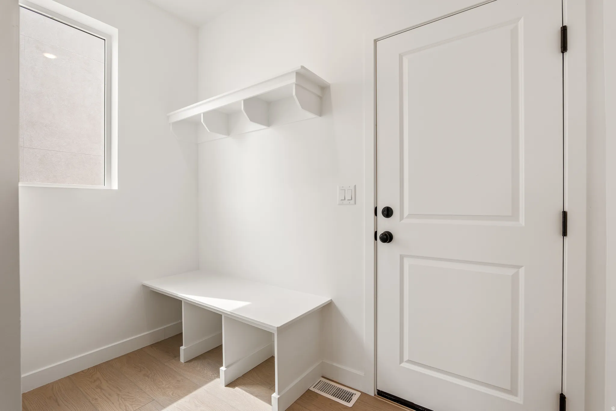 Entryway featuring wood-finish flooring and a built-in bench