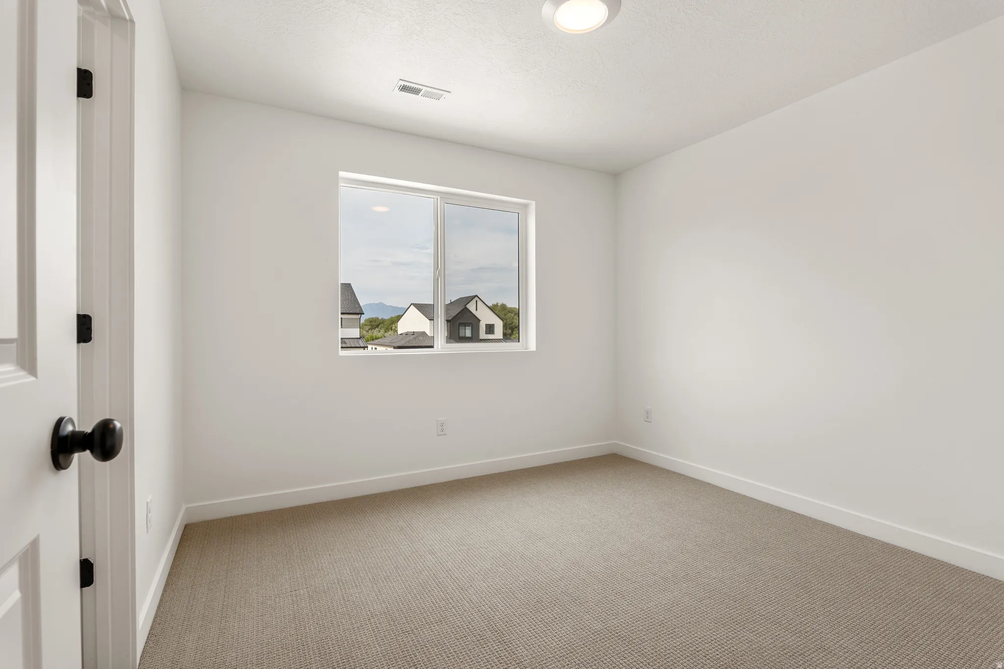 Neutral-toned carpeting paired with white baseboards and walls