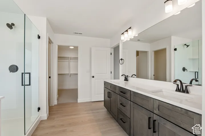 Modern bathroom featuring a double vanity with dark wood-finish cabinetry, white countertops, and matte black fixtures