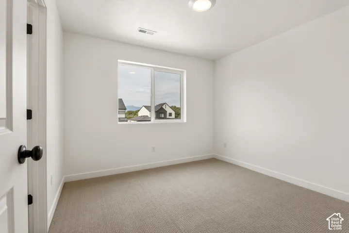 Neutral-toned carpeting paired with white baseboards and walls
