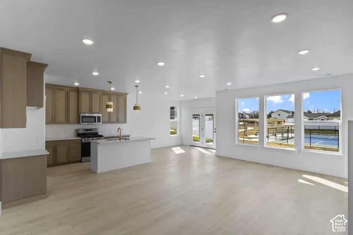 Open-concept living area featuring light wood-finish flooring and recessed lighting