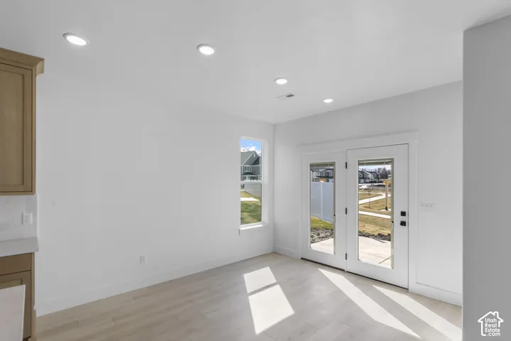 Light wood-finish flooring complements the neutral wall color