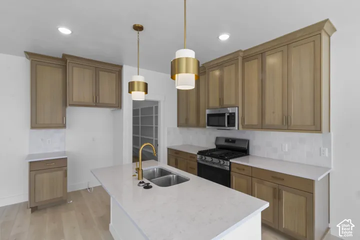 Spacious kitchen featuring an island with a double basin sink and gooseneck faucet