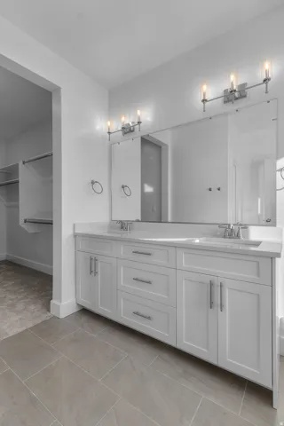 Primary bathroom. Dual vanity with white shaker-style cabinetry, a white countertop, and integrated sinks