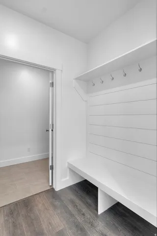 Built-in mudroom bench with shiplap backing and overhead shelving