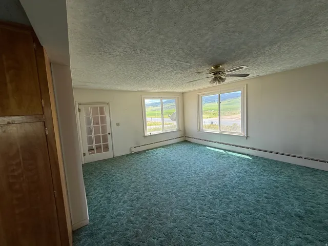Spacious room featuring broad windows showcasing a distant mountainous landscape