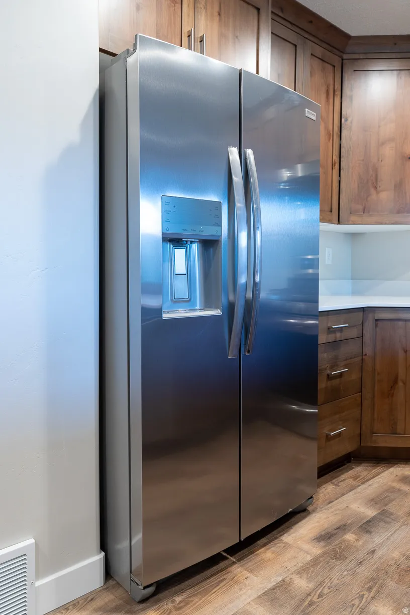 Stainless steel side-by-side refrigerator with an integrated ice and water dispenser