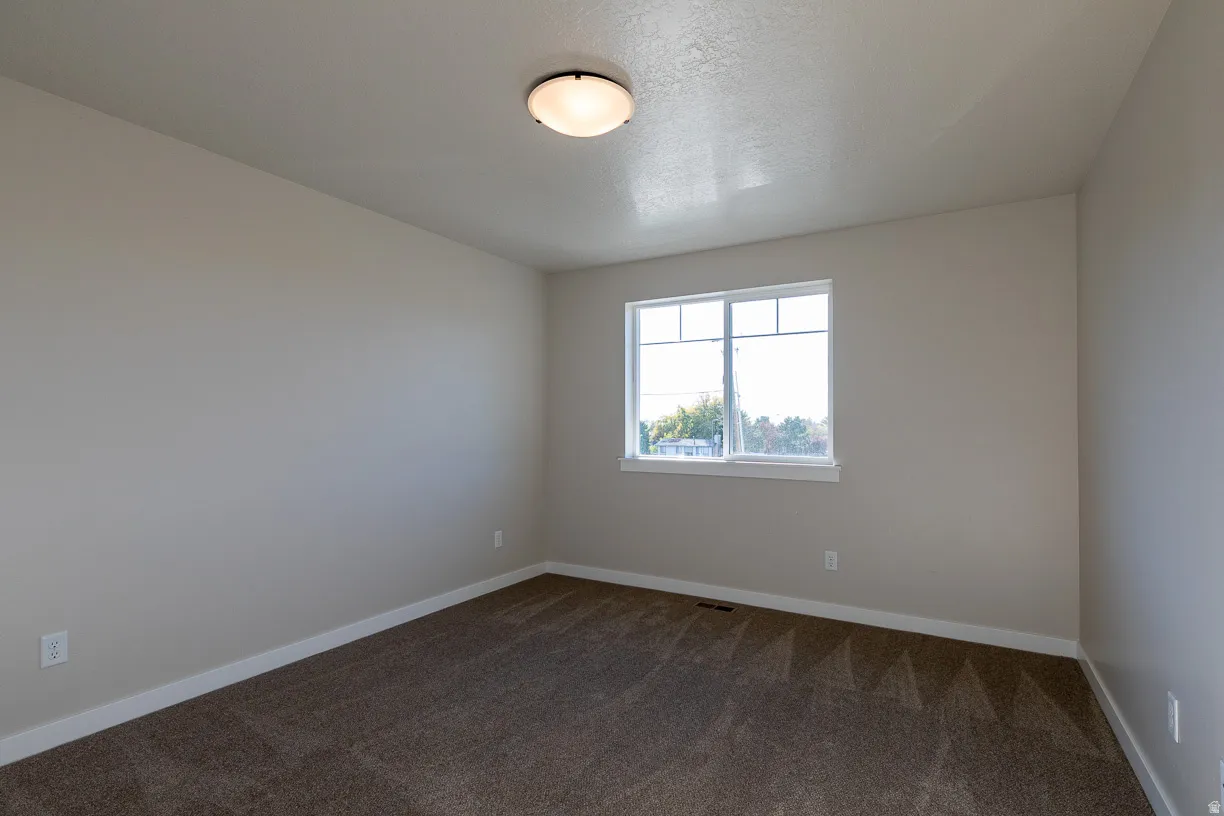 Bedroom Neutral wall color throughout, featuring a double-paned window, white trim, and a flush-mount ceiling light