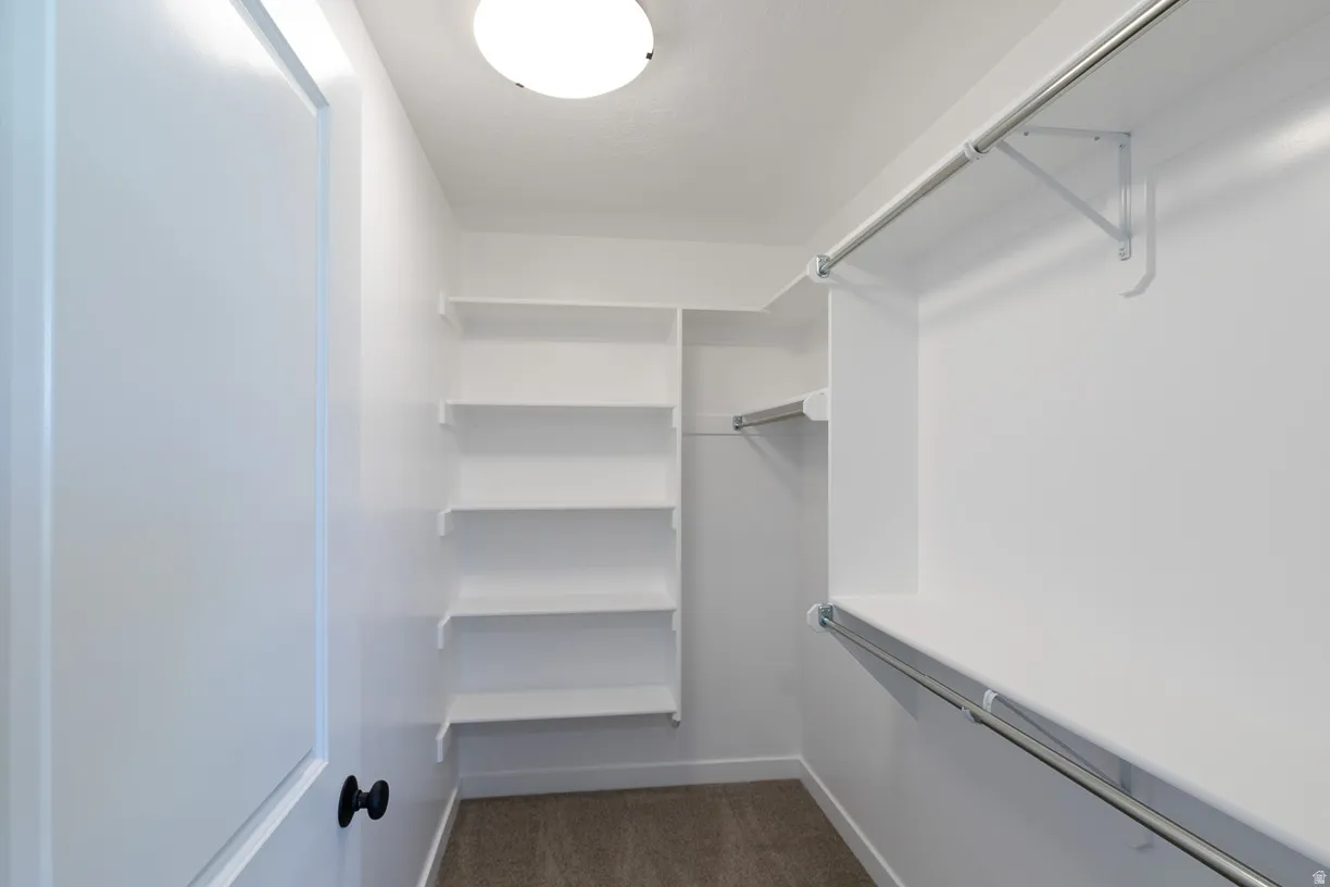 Primary bedroom walk-in closet featuring built-in shelving, multiple hanging rods, and recessed lighting