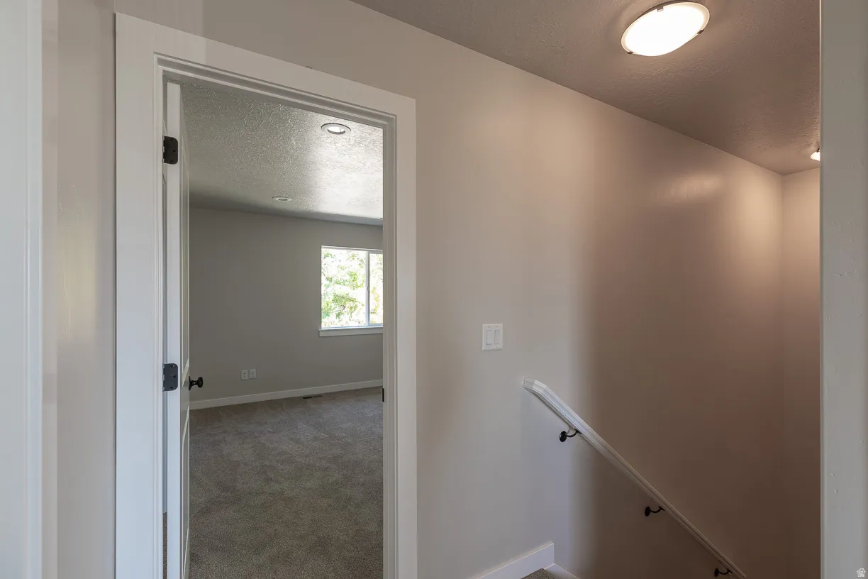 Carpeted room with a double window, recessed lighting, and a white door with black hardware
