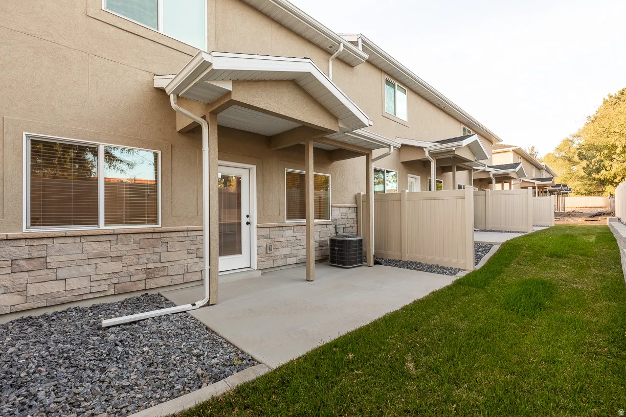 Rear patio with concrete surface and stone veneer accents