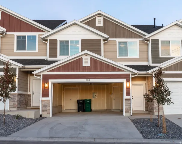Townhome exterior featuring varied siding materials, stone accents, and an integrated garage