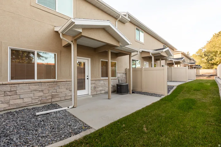 Rear patio with concrete surface and stone veneer accents